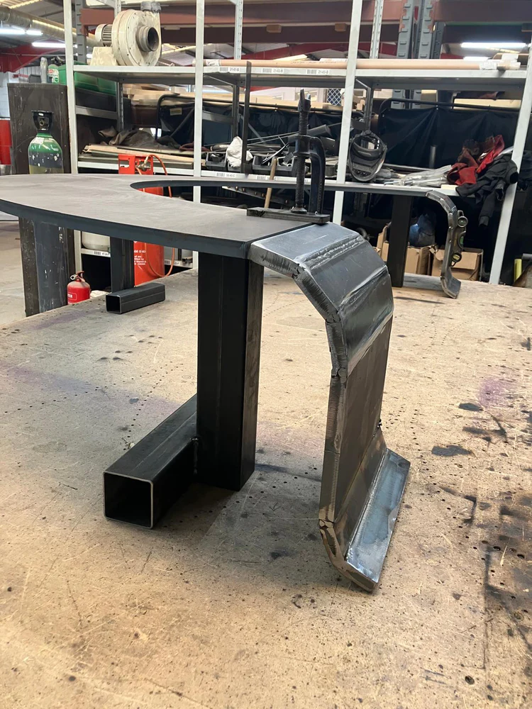 A welded, curved bench